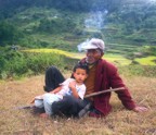 A man and his grandson take a break from working in the rice terraces