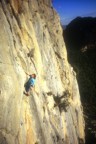 Climber pulls the roof at the end of the first pitch (6a)
