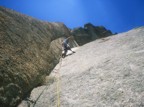 Climbing the crux bulge on the second pitch; the difficulty of this pitch is in placing gear, as it's thin and technical