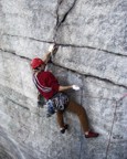 Clipping the second piece of gear at the start of the crux