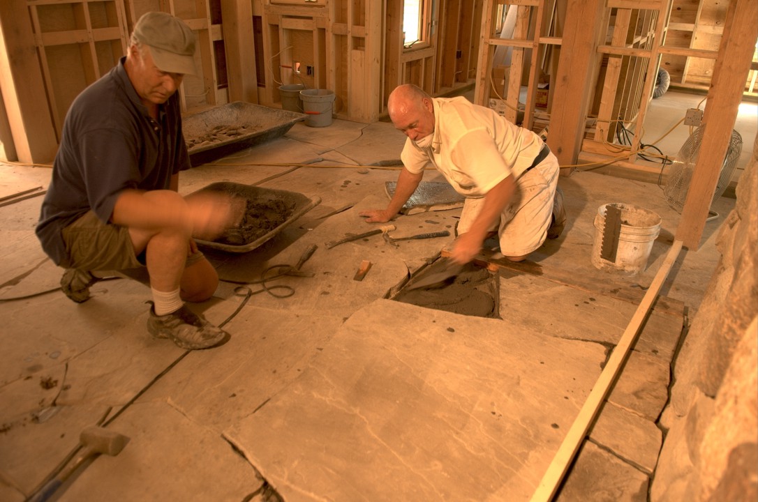 Mark and his brother Phil cement the floor stones into position