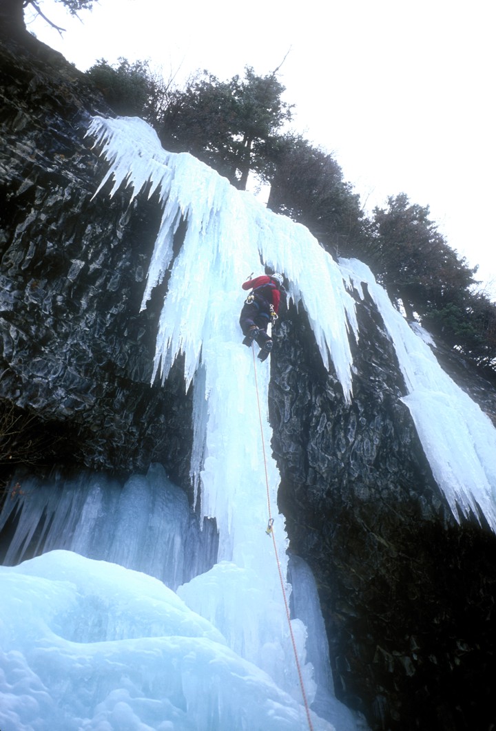 Climbing the thin column on Omega; the ice was running with water
