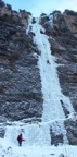 Leading the thin ice on the first pitch of Called; the route steepens just above, then stretches the rope to the cave visible beneath a hanging pillar on the right